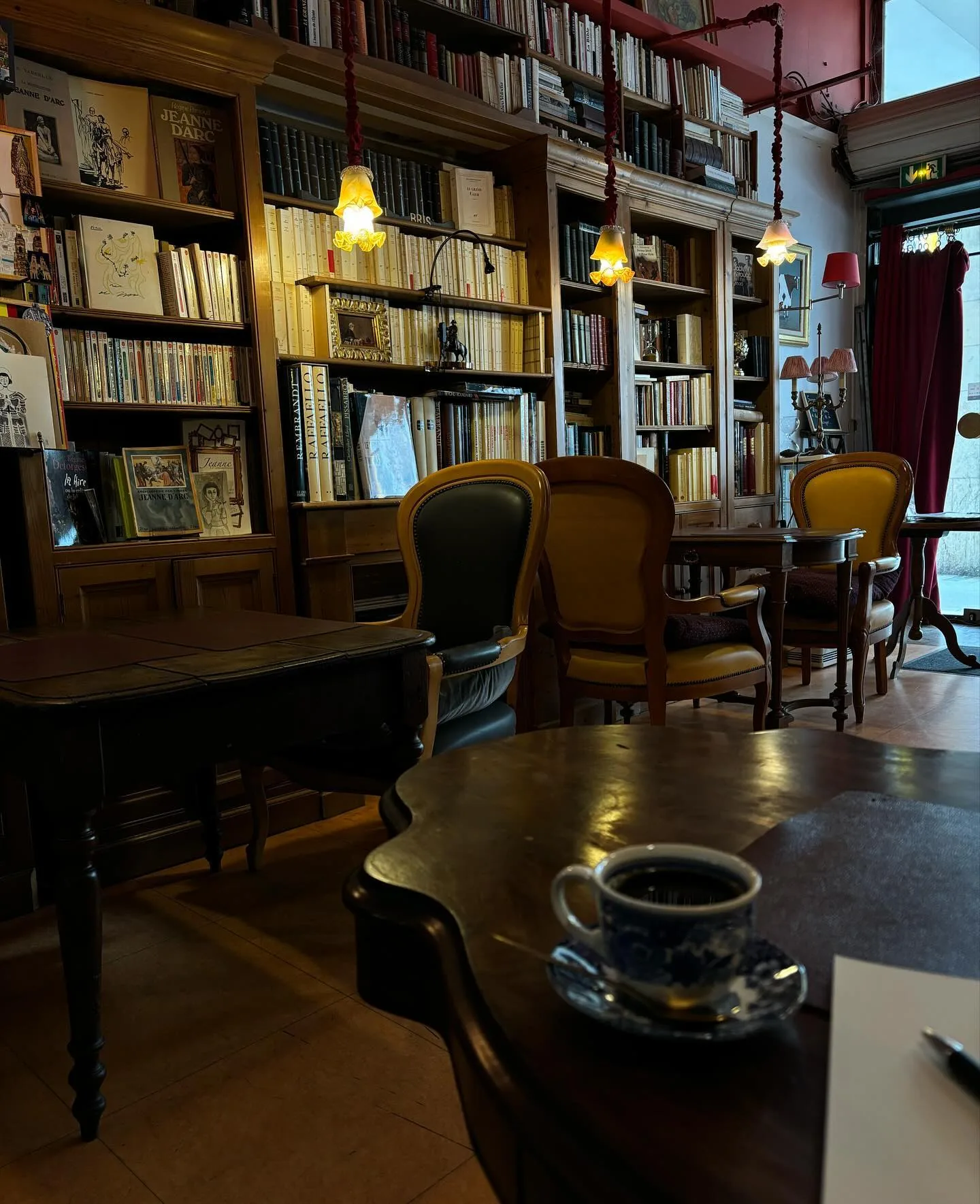 Tables en bois sombre et tasse de thé dans la pénombre du salon