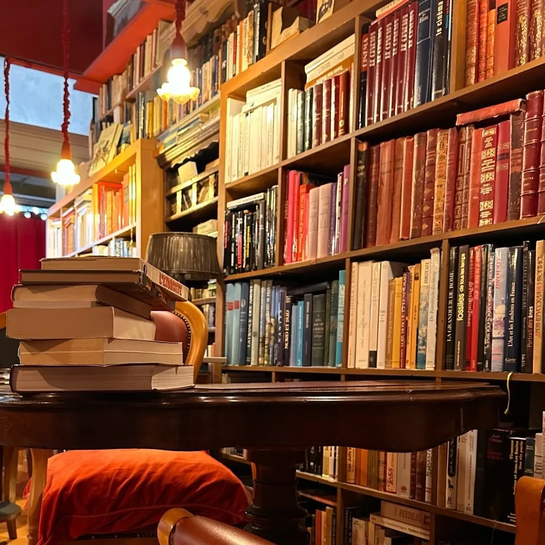 Coin lecture : pile de livres sur un guéridon, sous une lampe chaude